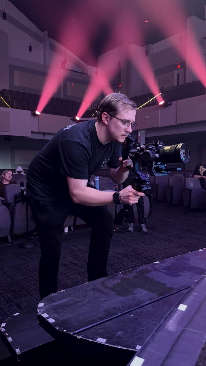 Zachary Schermerhorn operating a gimbal camera during a live stage production